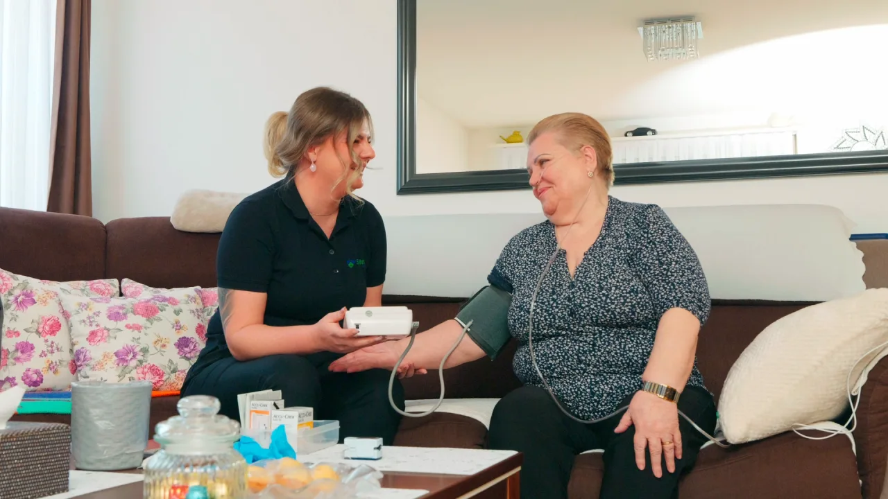 Mitarbeiterin von Spitex Glatt misst einer Patientin zu Hause den Blutdruck.